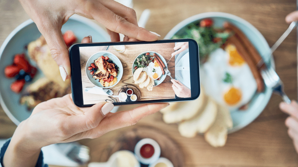 person taking overhead photo of food on phone