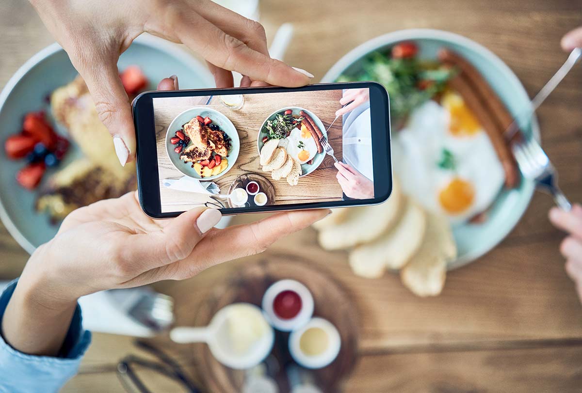 Person photographing food on smartphone