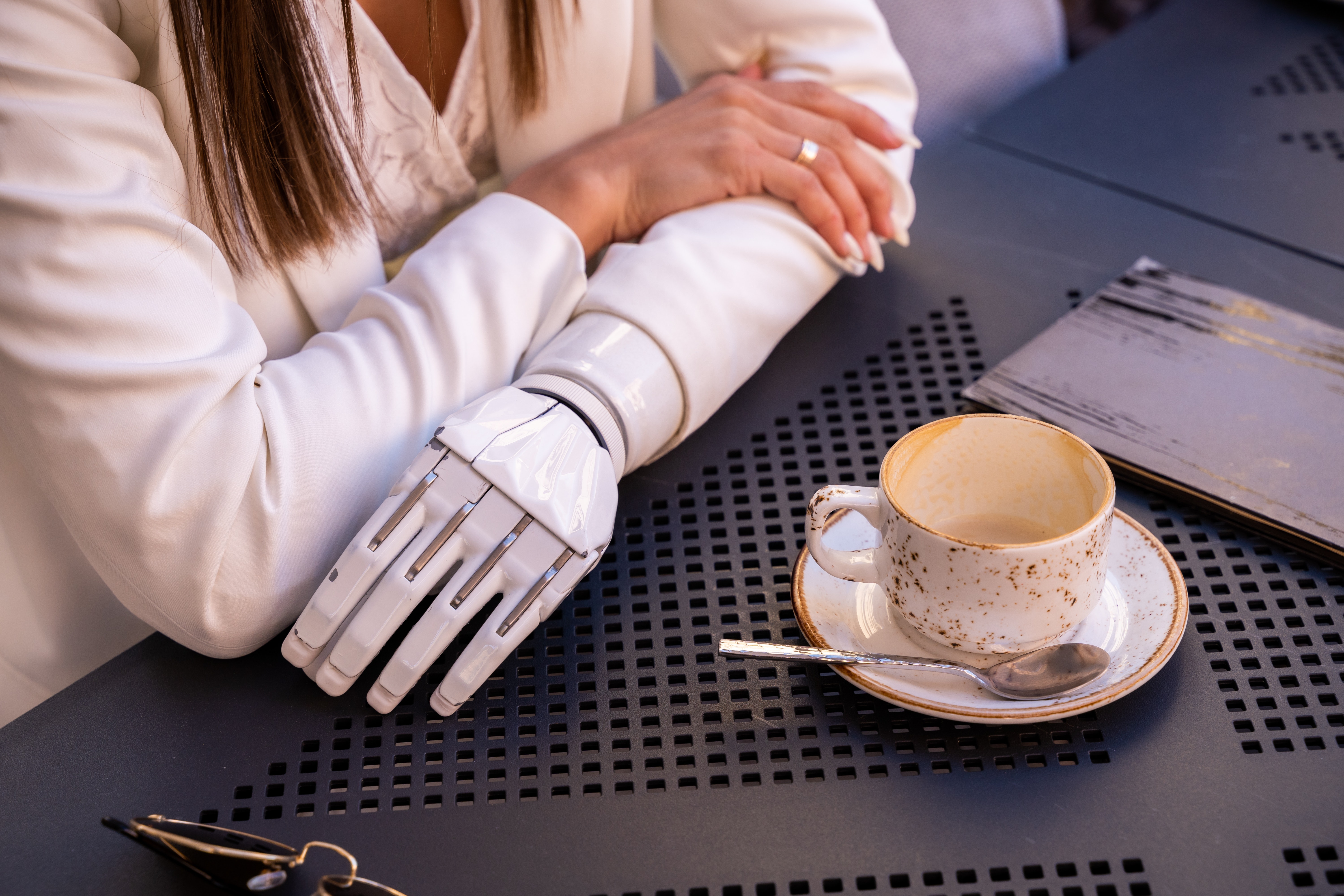 Woman with robot arm having coffee